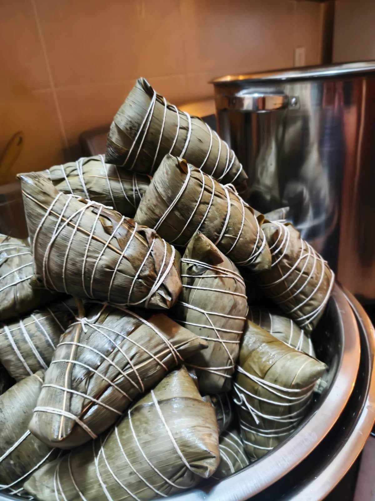 A steamer pot full of You Yi’s sticky rice dumplings (zongzi), tied in bamboo leaves.