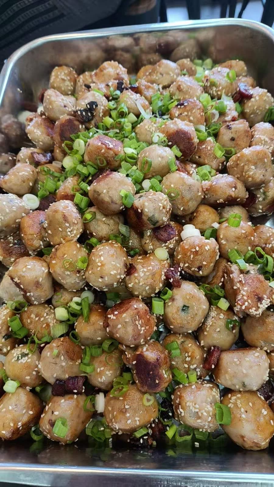 A prep tray of You Yi’s taro balls, fried and topped with sesame, scallion, and crushed peanuts.